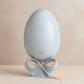 Uovo Dea in ceramica Capodimonte H 22 cm colore polvere con fiocco oro